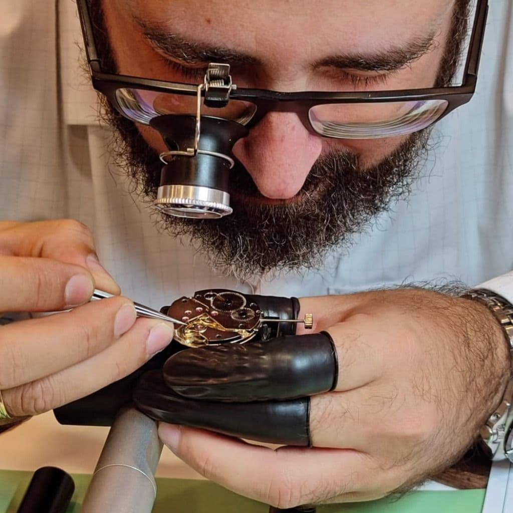 Relojero trabajando en un reloj de precisión